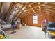 Spacious unfinished attic room with exposed rafters, a window for natural light, and ample storage space at 81 Dot Ct, Fuquay Varina, NC 27526