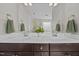Bathroom with double vanity, marble countertop, large mirror and decorative plant at 81 Dot Ct, Fuquay Varina, NC 27526