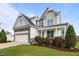 Attractive home featuring a stone-accented garage, inviting front porch, and well-maintained landscaping at 81 Dot Ct, Fuquay Varina, NC 27526
