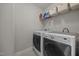 Practical laundry room with a front-load washer and dryer, shelf storage, and light tile flooring at 81 Dot Ct, Fuquay Varina, NC 27526
