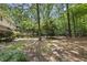 The backyard has a wooden deck, lush trees, and natural landscaping and shade at 821 Ascot Ln, Raleigh, NC 27615
