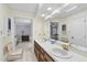 Bright bathroom featuring double sinks, a large mirror, and a glimpse into an adjacent bedroom at 821 Ascot Ln, Raleigh, NC 27615