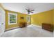 Vibrant yellow bedroom with two windows, and a colorful ceiling fan at 821 Ascot Ln, Raleigh, NC 27615