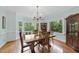Bright dining room with large windows, hardwood floors and an elegant chandelier at 821 Ascot Ln, Raleigh, NC 27615