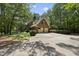 Brick house with a two-car garage, surrounded by lush green trees with ample parking space at 821 Ascot Ln, Raleigh, NC 27615