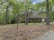 Traditional brick home with a well-manicured lawn, mature trees, and elegant landscaping at 821 Ascot Ln, Raleigh, NC 27615