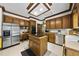 Traditional kitchen featuring wood cabinets, stainless steel appliances, and a central island cooktop at 821 Ascot Ln, Raleigh, NC 27615