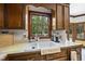 Kitchen sink with a view of the lush backyard, wood cabinetry, and natural light at 821 Ascot Ln, Raleigh, NC 27615