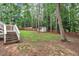 Lush backyard with mature trees, a shed, and a wooden fence, offering privacy and space at 8801 Valley Hill Ct, Apex, NC 27539