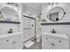 Bright bathroom featuring dual vanities with round mirrors, a walk-in shower with white subway tile, and modern fixtures at 8801 Valley Hill Ct, Apex, NC 27539