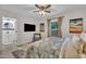 Bright bedroom featuring a ceiling fan, tv, chair and direct bathroom access at 8801 Valley Hill Ct, Apex, NC 27539