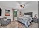 Stylish bedroom featuring a ceiling fan, chair, artwork, and natural light through the window at 8801 Valley Hill Ct, Apex, NC 27539