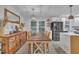 Well-lit dining room with a wooden table set, complemented by rustic decor, and an open view into a modern kitchen at 8801 Valley Hill Ct, Apex, NC 27539