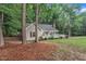 Serene view of a single-story home nestled among mature trees, enhancing its curb appeal at 8801 Valley Hill Ct, Apex, NC 27539