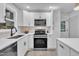 Well-organized kitchen featuring white cabinetry, sleek appliances, a subway tile backsplash, and a modern black sink at 8801 Valley Hill Ct, Apex, NC 27539