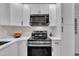 Modern kitchen features stainless steel microwave and range oven with bright white cabinets at 8801 Valley Hill Ct, Apex, NC 27539