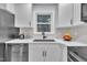 Clean kitchen featuring white countertops, a black sink, a modern faucet, and overhead cabinets, with a view from the window at 8801 Valley Hill Ct, Apex, NC 27539