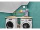 Well-organized laundry room with teal walls, a wooden countertop, washer, and dryer at 8801 Valley Hill Ct, Apex, NC 27539