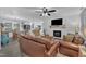 Open-concept living room featuring a fireplace, ceiling fan, and comfortable seating, blending seamlessly with dining and kitchen areas at 8801 Valley Hill Ct, Apex, NC 27539