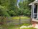 Fenced backyard with grassy lawn adjoins the side porch area of this charming blue house at 105 Hanna St, Carrboro, NC 27510