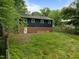 Photo of the rear exterior with a brick foundation and large, grassy backyard at 105 Hanna St, Carrboro, NC 27510