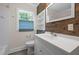 Modern bathroom with updated fixtures and ample lighting plus stylish wood accent wall at 105 Hanna St, Carrboro, NC 27510