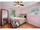 Cozy pink bedroom with a comfortable bed, natural light, and a ceiling fan at 110 Starlite Dr, Carrboro, NC 27510
