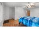 Bedroom with hardwood floors, neutral walls, a ceiling fan, and comfortable bed with blue bedding at 110 Starlite Dr, Carrboro, NC 27510