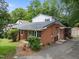 Charming front exterior showcasing the home's brick facade and metal roof at 110 Starlite Dr, Carrboro, NC 27510