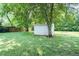 Backyard featuring a shed and lush green trees at 1146 W Holt St, Mebane, NC 27302