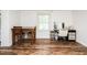 Bright room featuring a dining table and chair, a desk with make up vanity set, and wood laminate flooring at 1146 W Holt St, Mebane, NC 27302
