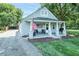 View of the home showcasing the cute covered porch, American flag, and brick exterior at 1146 W Holt St, Mebane, NC 27302