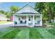 Charming home featuring a welcoming front porch, flag, and a well-manicured lawn at 1146 W Holt St, Mebane, NC 27302