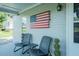 Covered porch with brick columns, black chairs, and a unique American flag at 1146 W Holt St, Mebane, NC 27302