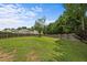 Large grassy backyard enclosed by a wooden fence offering privacy and space at 119 Tadworth Ct, Mebane, NC 27302