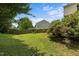 Lush backyard with mature trees, a swing set, and a view of neighboring homes at 119 Tadworth Ct, Mebane, NC 27302