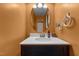 Stylish half bath with a black vanity, bright lighting, oval mirror, and decorative accents at 119 Tadworth Ct, Mebane, NC 27302