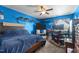 Bright blue bedroom with a comfortable bed, TV, and ample shelf space offers a cozy and organized living area at 119 Tadworth Ct, Mebane, NC 27302