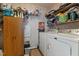 This functional laundry room includes a washer, dryer, storage cabinet, and shelving for organization and convenience at 119 Tadworth Ct, Mebane, NC 27302