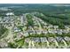 Expansive aerial view of a residential community surrounded by lush greenery, featuring well-maintained homes and winding roads at 121 Hardy Oaks Way, Holly Springs, NC 27540
