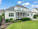 Rear view highlighting the home's screened in porch, patio and lush green lawn at 121 Hardy Oaks Way, Holly Springs, NC 27540