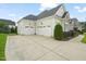 Three car garage with ample driveway space and manicured landscaping at 121 Hardy Oaks Way, Holly Springs, NC 27540
