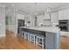 Bright kitchen featuring white cabinets, a large island with seating, and stainless steel appliances at 121 Hardy Oaks Way, Holly Springs, NC 27540