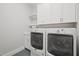 Bright laundry room features modern appliances, ample cabinet space, and a convenient wash basin at 121 Hardy Oaks Way, Holly Springs, NC 27540