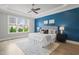 Spacious main bedroom boasts a tray ceiling, large window, and designer color scheme at 121 Hardy Oaks Way, Holly Springs, NC 27540
