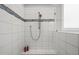 Bright shower featuring white tile with decorative accent stripe and bronze shower fixtures at 121 Hardy Oaks Way, Holly Springs, NC 27540