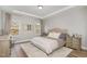 Serene primary bedroom featuring tray ceilings, neutral decor, and abundant natural light at 1428 Wrenn Rd, Durham, NC 27703