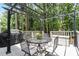 An outdoor deck with metal table and chairs, grill, and storage box at 2422 Castleburg Dr, Apex, NC 27523