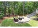 A backyard stone patio with outdoor furniture surrounded by tall mature trees at 2422 Castleburg Dr, Apex, NC 27523