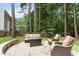 A backyard stone patio with outdoor furniture surrounded by tall mature trees at 2422 Castleburg Dr, Apex, NC 27523